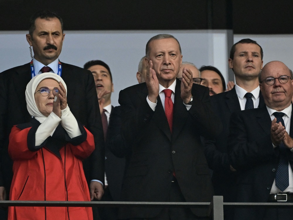 Erdogan (m.) reiste extra für das Viertelfinale an (Foto: AFP/SID/JOHN MACDOUGALL)